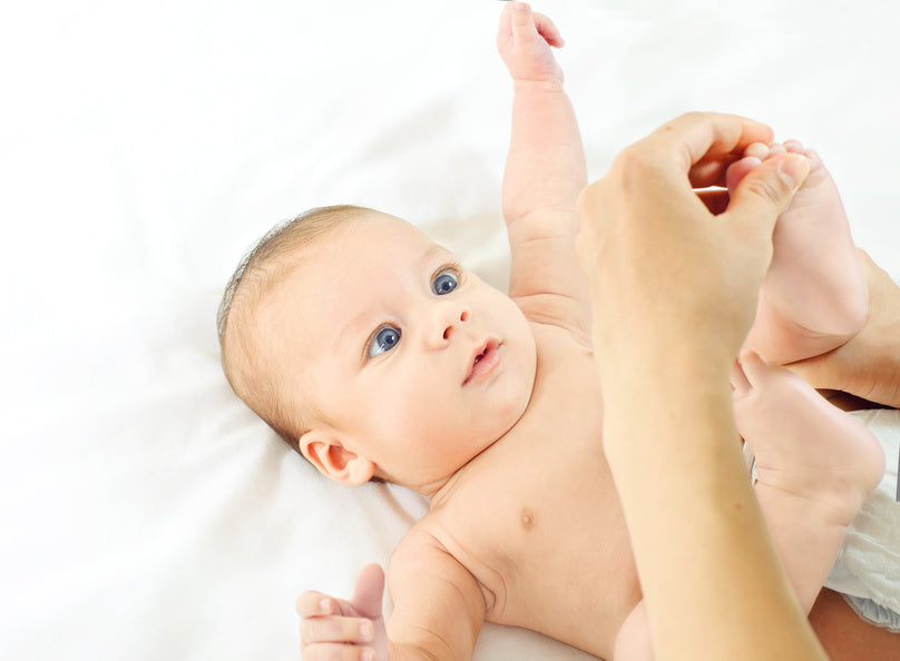 Mother massaging a baby's foot | Nourish Baby