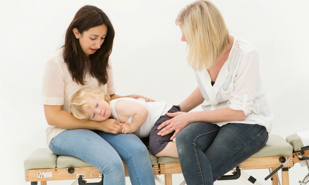 Chiropractor with young child and mother | Nourish Baby