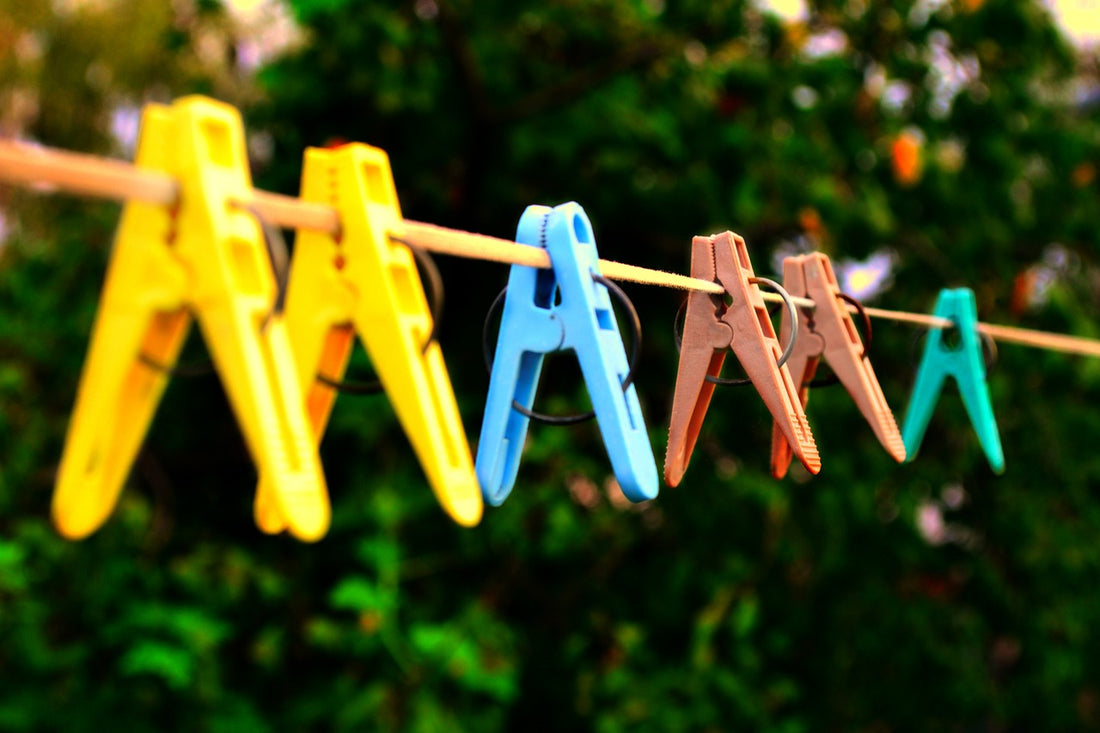 Colourful plastic clothes pegs on a clothes line  | Nourish Baby