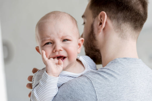 Man holding baby on his shoulder | Nourish Baby
