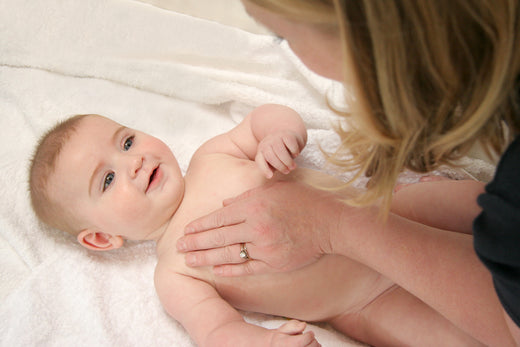 Baby being massaged by mother | Nourish Baby