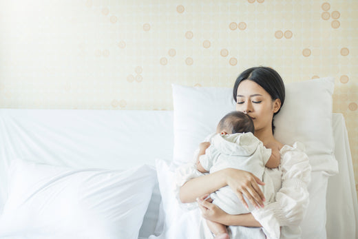 Mother with baby in bed | Nourish Baby
