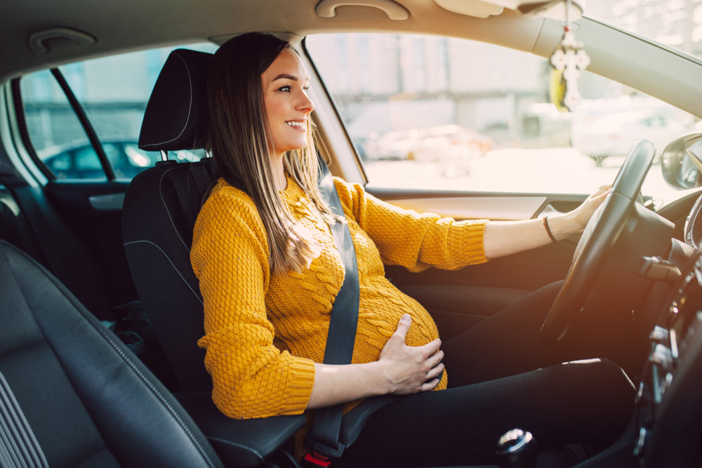Pregnant woman in drivers seat of car | Nourish Baby