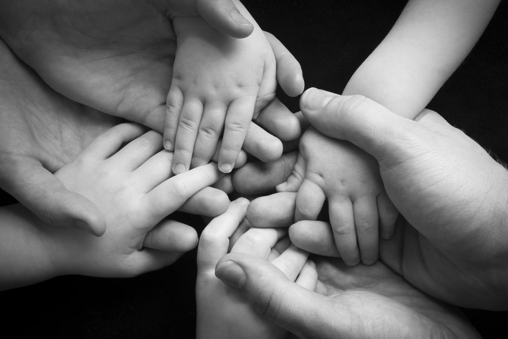 Adult hands holding childs hands | Nourish Baby