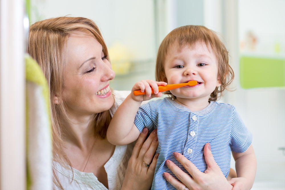 Toddler brushing teeth with mother | Nourish Baby